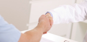 Arzt und Patient reichen sich die Hände